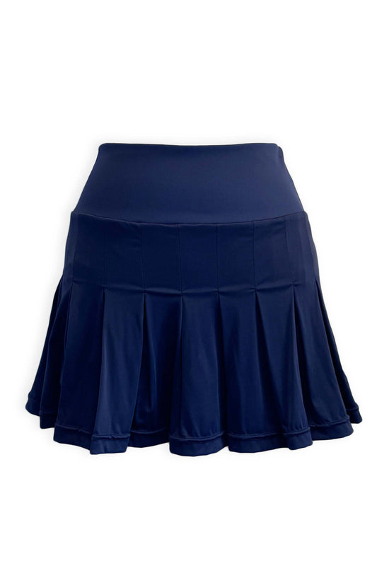 Navy pleated tennis skirt in soft, stretchy and sustainable fabric. Built in shorts with pockets in peach and white seersucker fabric with the brand's Mongoose logo.