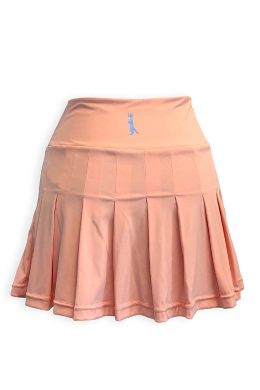 Peach pleated tennis skirt in soft, stretchy and sustainable fabric. Built in shorts with pockets in blue and white seersucker fabric with the brand's Mongoose logo printed on the back of the waist.