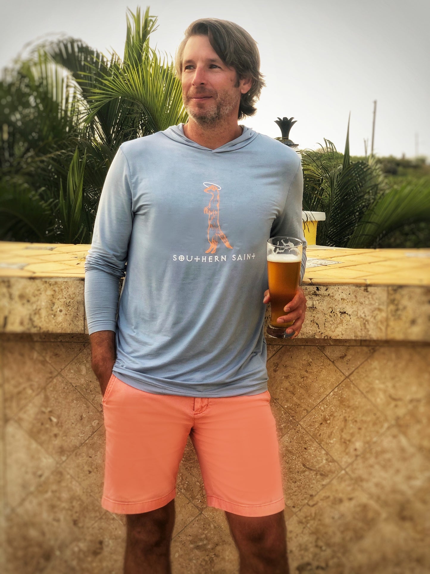 Our best selling Hooded Apres-sun shirt is a top seller for a reason...cooling, anti-microbial and perfect for throwing on after a day at the beach or for the long boat ride home. Shown in Chambray with Peach and white Southern Saint logo printed on the front.