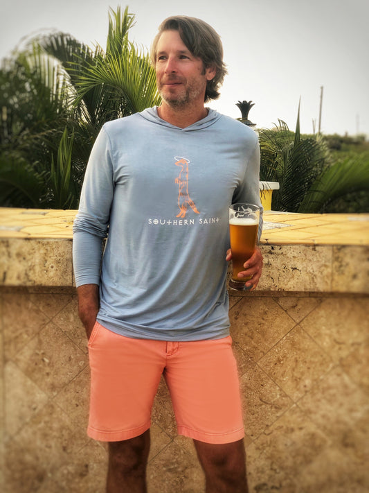 Our best selling Hooded Apres-sun shirt is a top seller for a reason...cooling, anti-microbial and perfect for throwing on after a day at the beach or for the long boat ride home.    Shown in Chambray with Peach and white Southern Saint logo printed on the front.