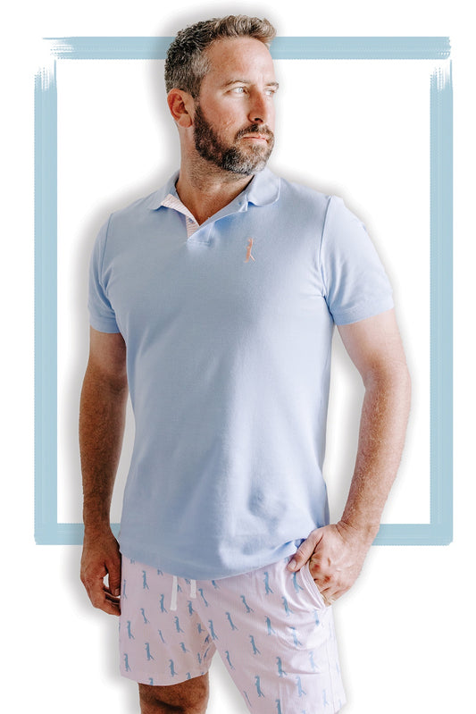 Beautiful knit polo in our signature Chambray blue with peach and white striping on the inside collar. Embroidered with our Saint Mongoose in peach on the left chest.  100% cotton